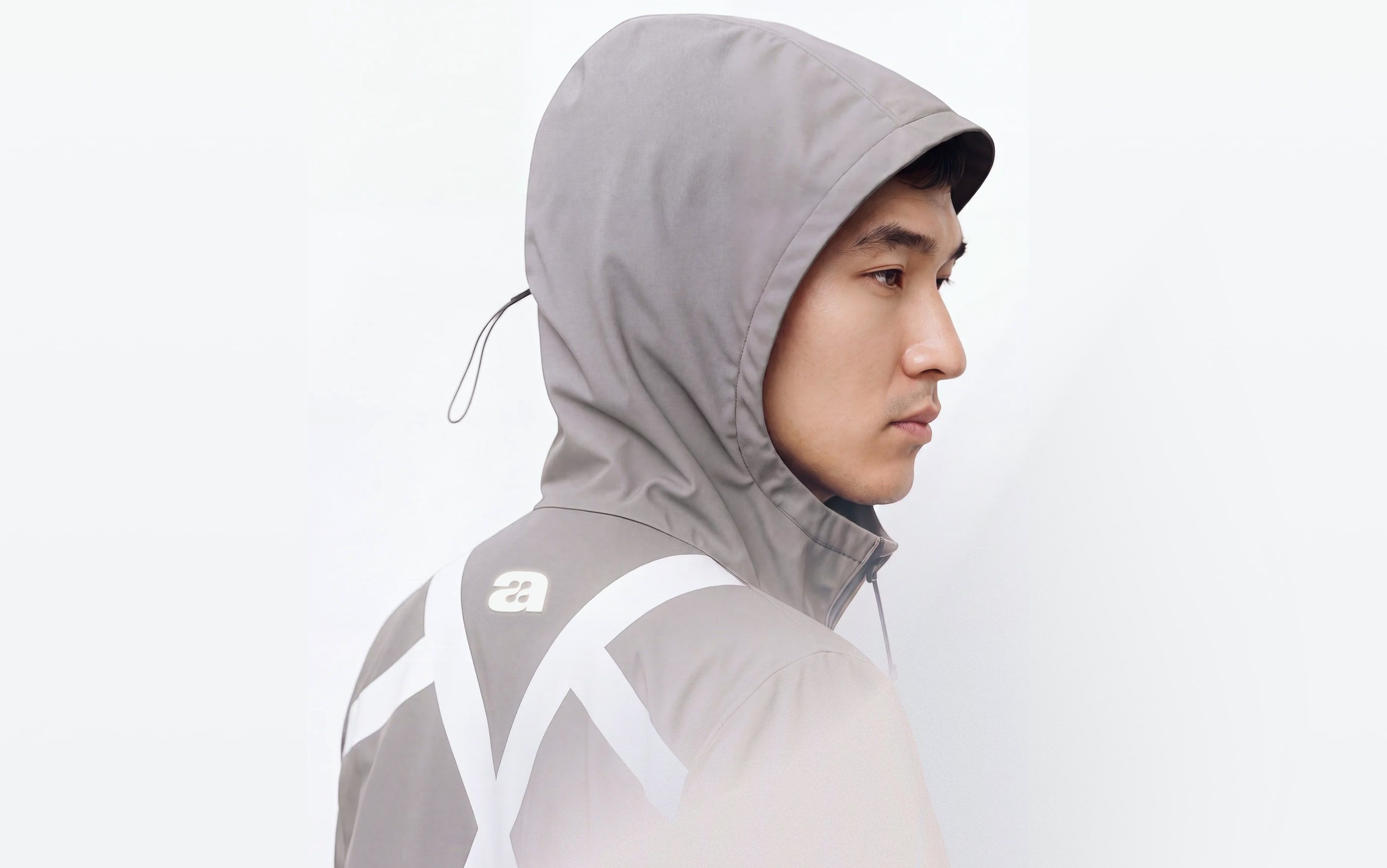 profile of a person wearing a grey maru uniform jacket with reflective graphics